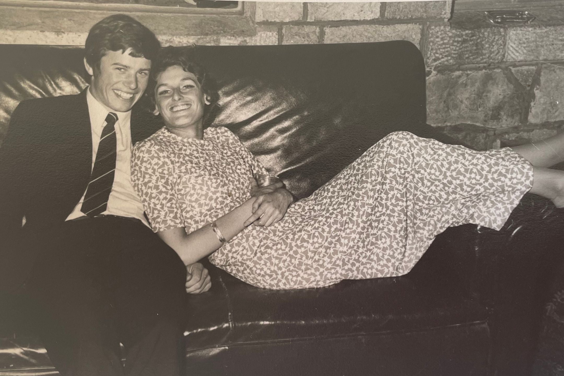 My parents in much younger days happily lounging on a sofa at a university ball.
