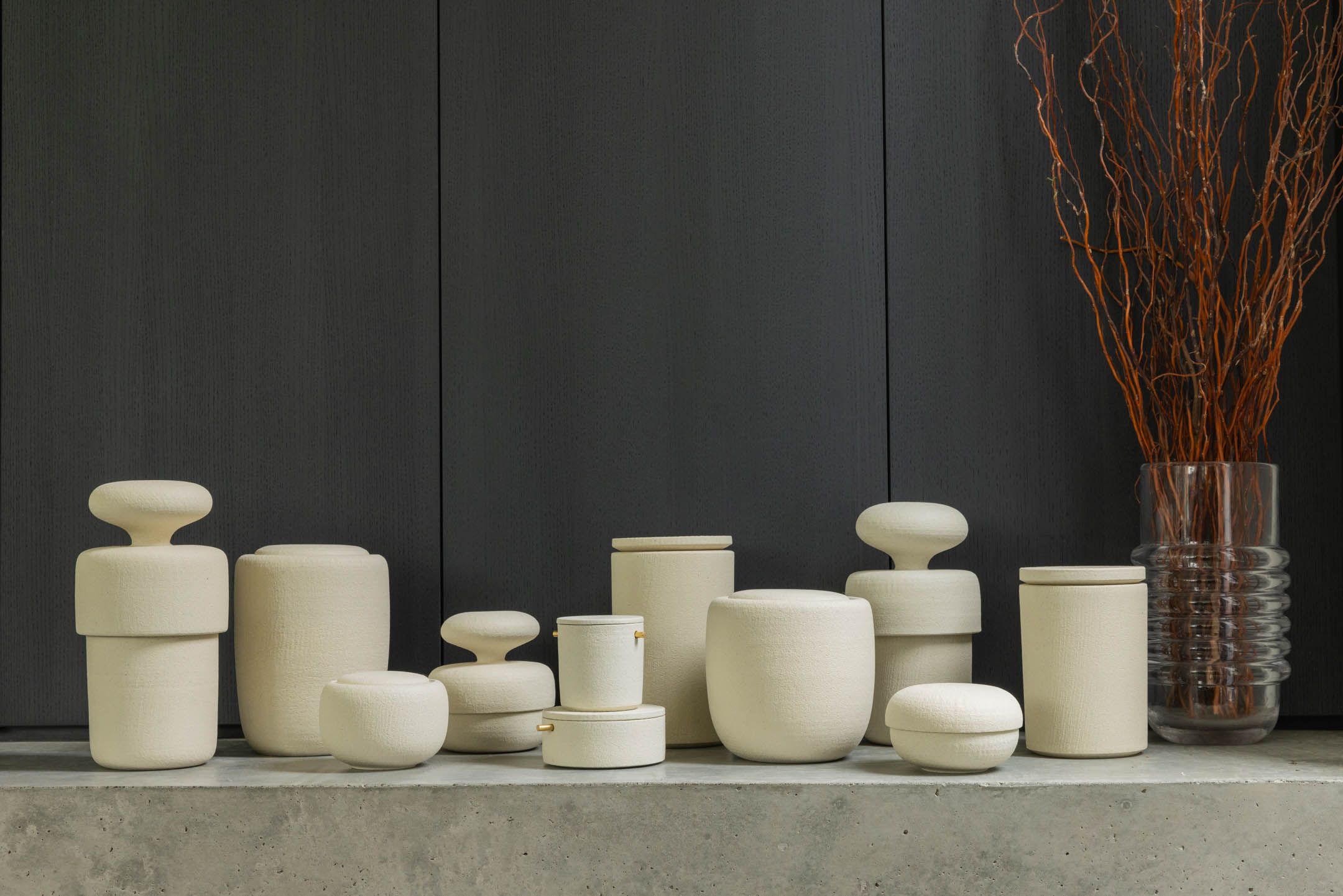Collection of beautiful handcrafted Vaso cremation urns on a modern concrete shelf - designed for contemporary homes